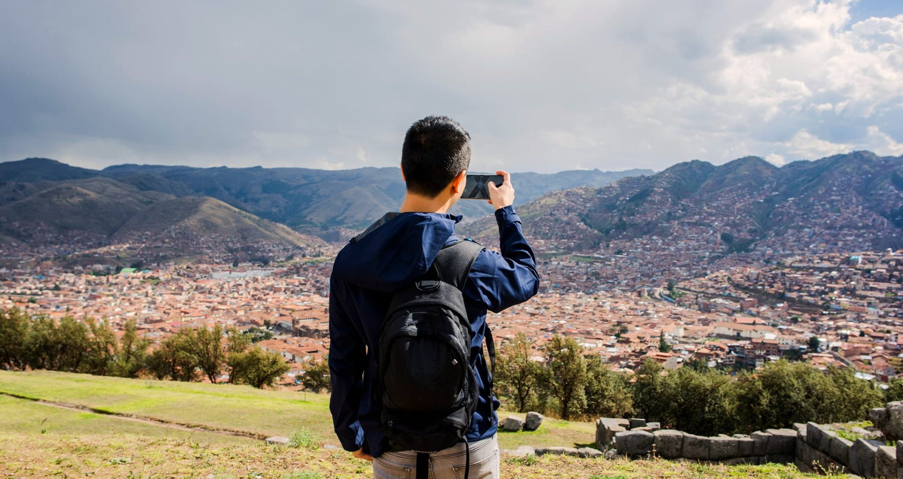 Viajero fotografiando la ciudad de Cusco desde un mirador
